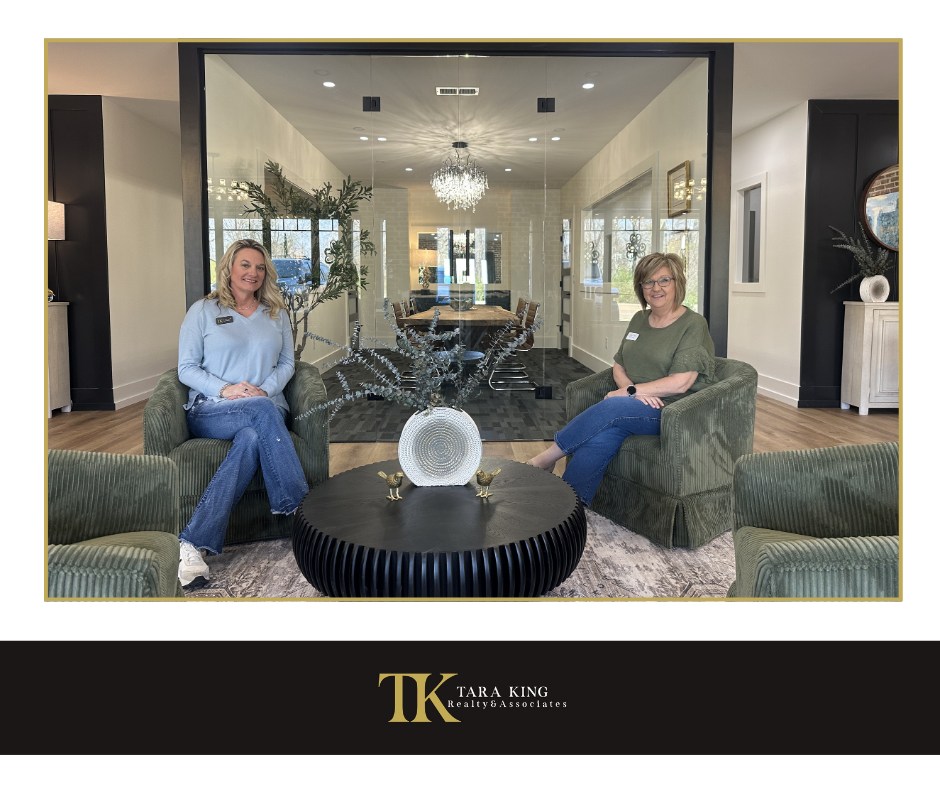 Tara King and Terri Wheat seated inside the real estate office.